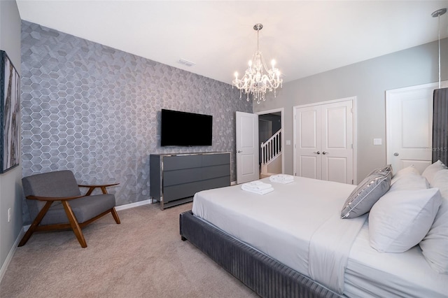 bedroom with a chandelier, light colored carpet, and a closet