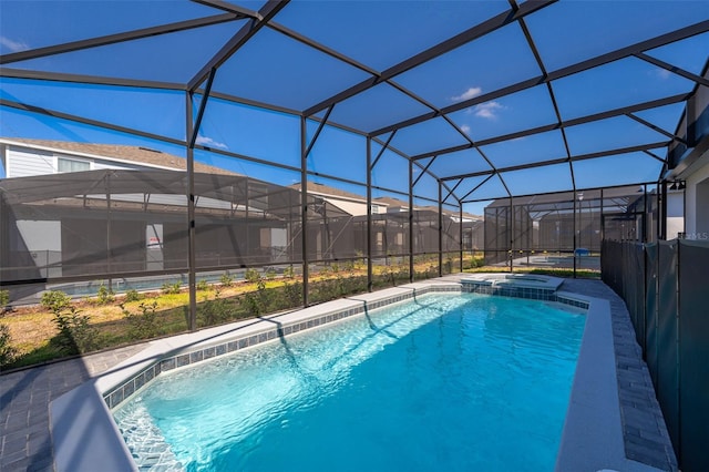 view of swimming pool featuring an in ground hot tub and glass enclosure