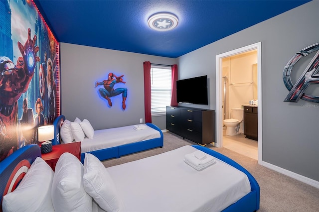 bedroom featuring ensuite bath, a textured ceiling, and light colored carpet