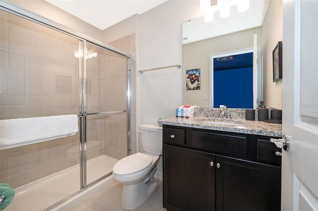 bathroom with vanity, toilet, tile patterned floors, and a shower with shower door