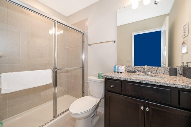 bathroom featuring toilet, an enclosed shower, vanity, and tile patterned flooring