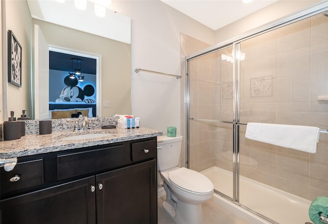 bathroom with vanity, toilet, and a shower with shower door