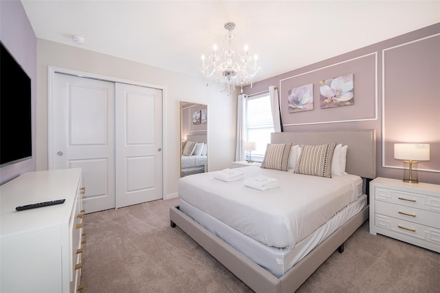 bedroom with a closet, an inviting chandelier, and light colored carpet