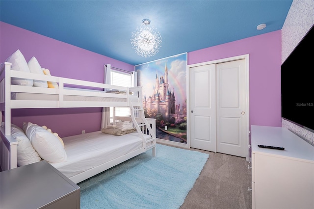 bedroom featuring light carpet, a closet, and a notable chandelier