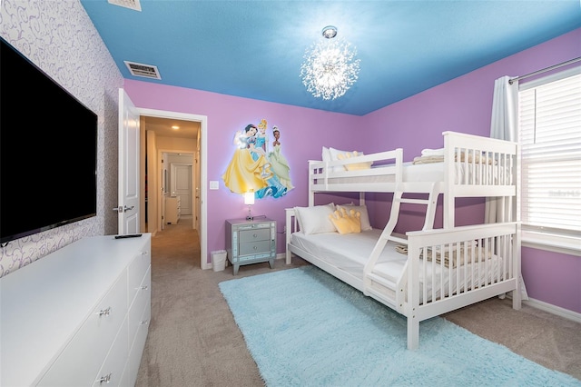 carpeted bedroom with a chandelier