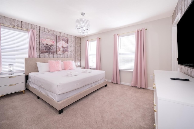 bedroom featuring light carpet and an inviting chandelier