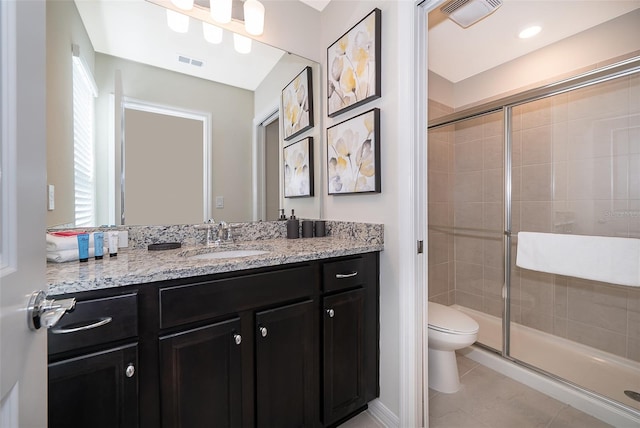 bathroom with vanity, tile patterned flooring, toilet, and an enclosed shower