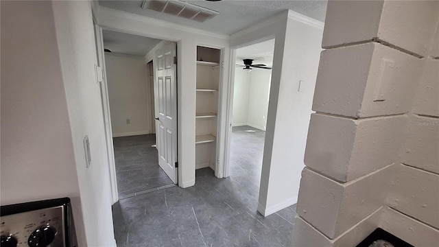 hallway with ornamental molding and a textured ceiling