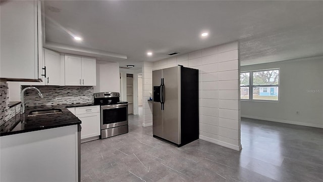 kitchen with stainless steel appliances, white cabinets, tasteful backsplash, and sink