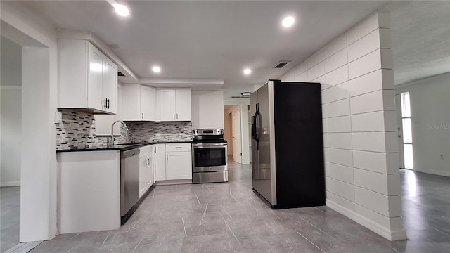 kitchen featuring white cabinets, backsplash, appliances with stainless steel finishes, and sink