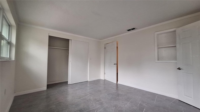 unfurnished bedroom with a closet and crown molding