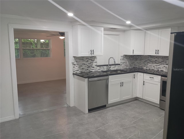 kitchen with stainless steel appliances, white cabinets, tasteful backsplash, and sink