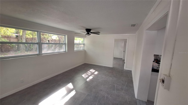 spare room with a textured ceiling, ceiling fan, and ornamental molding