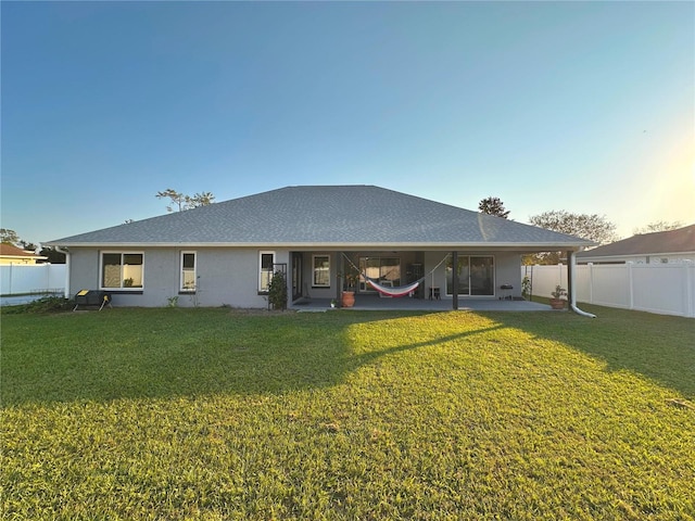 back of house featuring a patio area and a lawn