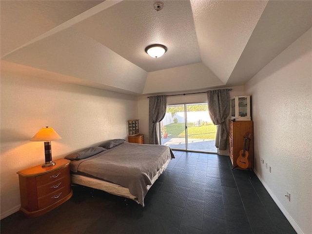 bedroom with access to outside, a textured ceiling, and lofted ceiling