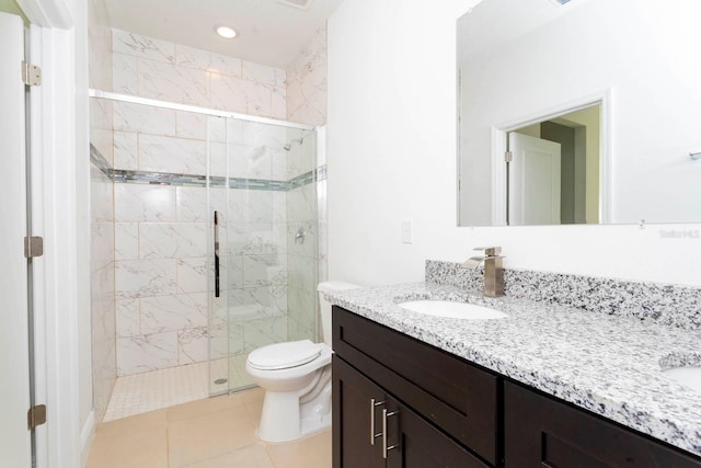 bathroom featuring toilet, vanity, tile patterned floors, and a shower with door