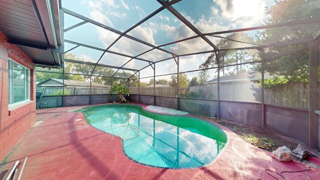 view of pool with a patio and glass enclosure