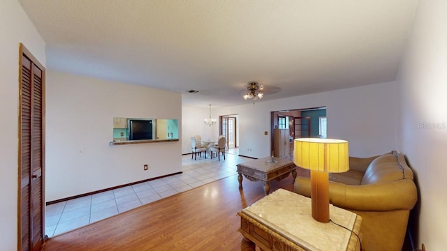 living room featuring light hardwood / wood-style flooring and ceiling fan with notable chandelier