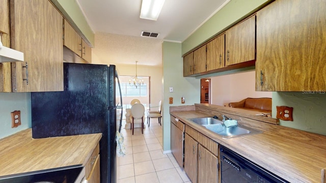 kitchen featuring ornamental molding, black appliances, sink, an inviting chandelier, and light tile patterned floors