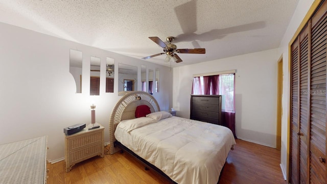 bedroom featuring hardwood / wood-style floors, a textured ceiling, and ceiling fan