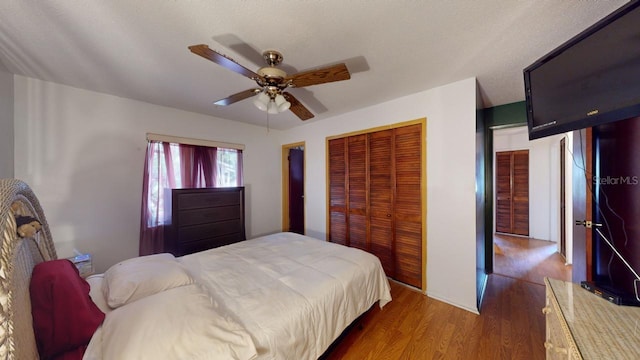 bedroom featuring dark hardwood / wood-style flooring, a textured ceiling, a closet, and ceiling fan