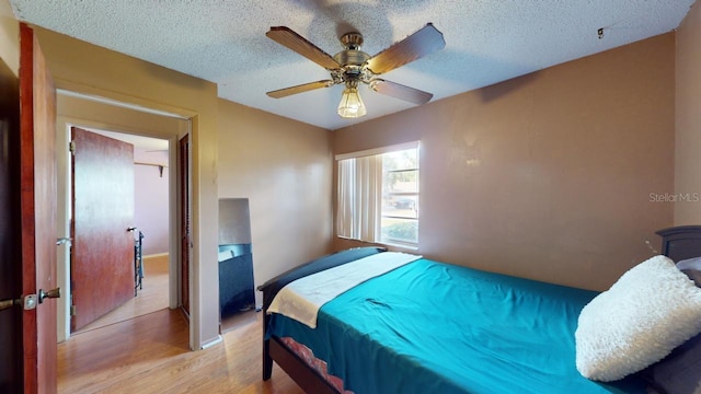 bedroom with light hardwood / wood-style floors, a textured ceiling, and ceiling fan