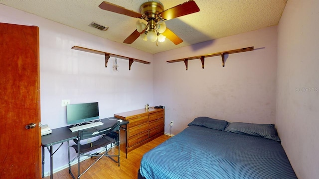 bedroom featuring ceiling fan, a textured ceiling, and hardwood / wood-style floors