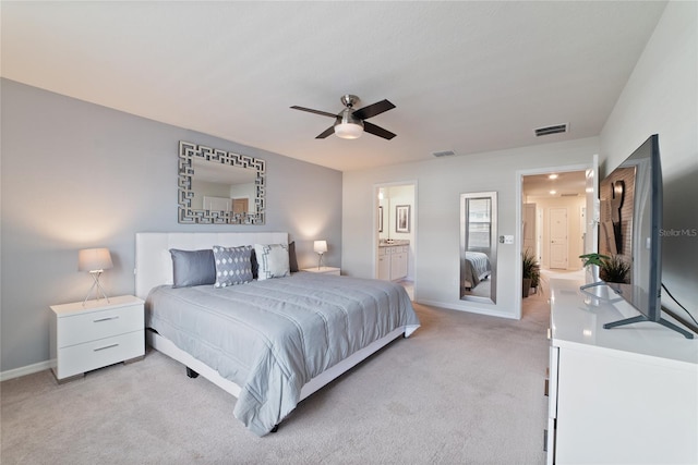 carpeted bedroom with ensuite bathroom and ceiling fan