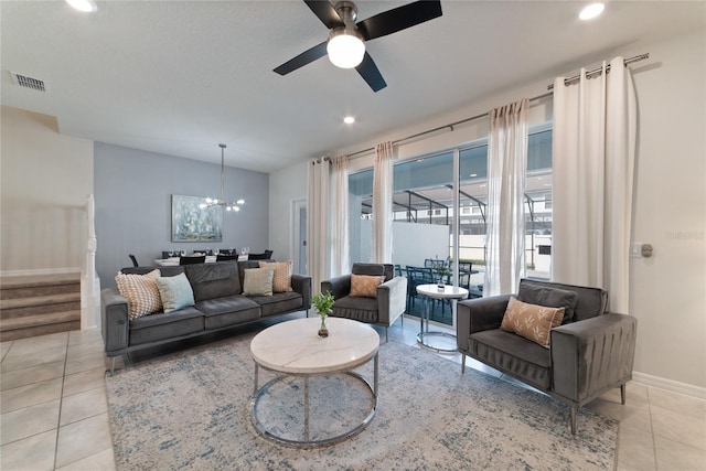 tiled living room featuring ceiling fan with notable chandelier