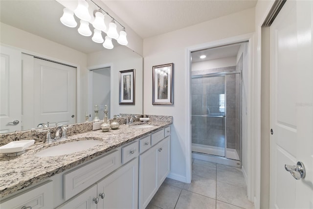 bathroom with a shower with door, a textured ceiling, vanity, and tile patterned floors