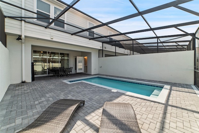 view of swimming pool with a patio area and glass enclosure