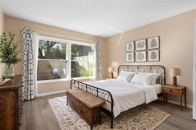 bedroom with hardwood / wood-style floors and a textured ceiling