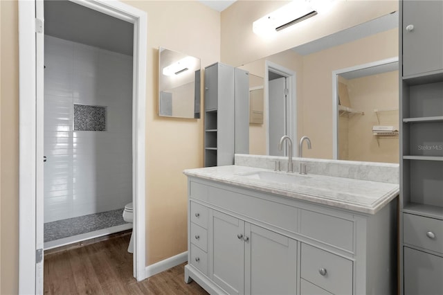 bathroom with vanity, hardwood / wood-style flooring, toilet, and walk in shower