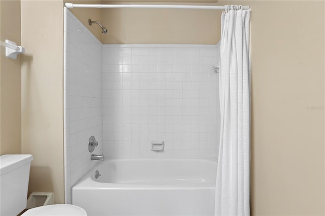 bathroom featuring shower / bath combo and toilet