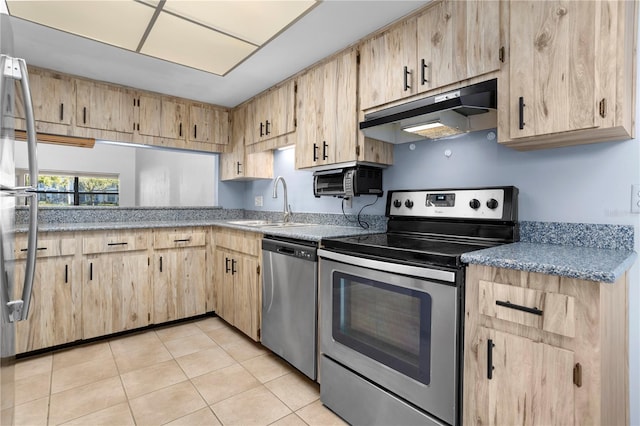 kitchen with appliances with stainless steel finishes, light brown cabinets, light tile patterned flooring, and sink