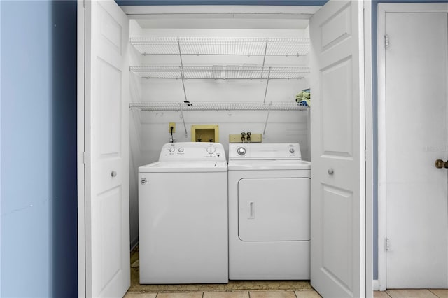 laundry area featuring washing machine and dryer and light tile patterned floors