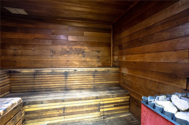 view of sauna / steam room featuring wooden ceiling and wood walls