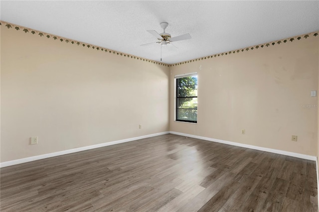 spare room with dark wood-type flooring, ceiling fan, and a textured ceiling