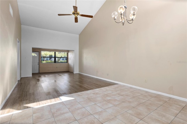 spare room with light hardwood / wood-style flooring, high vaulted ceiling, and ceiling fan with notable chandelier