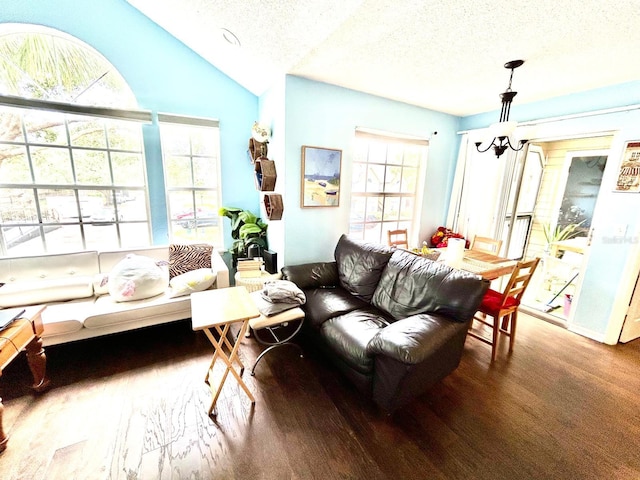 living room featuring a textured ceiling, a healthy amount of sunlight, a chandelier, and vaulted ceiling