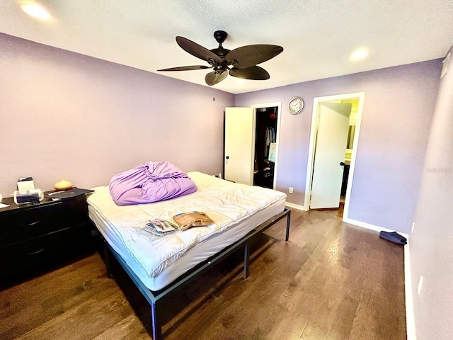 bedroom featuring a textured ceiling, ceiling fan, and dark hardwood / wood-style flooring