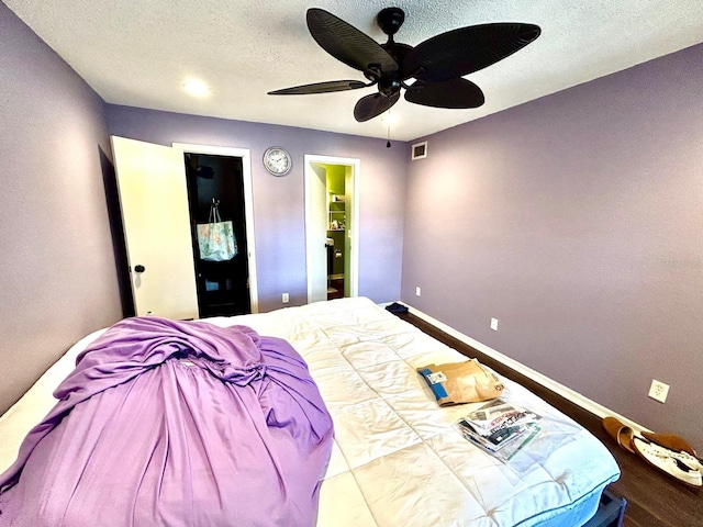 bedroom featuring a textured ceiling, hardwood / wood-style flooring, and ceiling fan