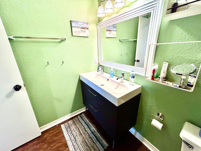 bathroom with toilet, hardwood / wood-style flooring, and vanity