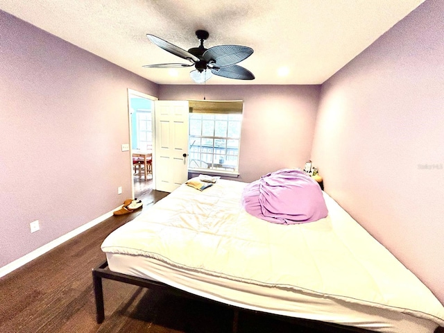 bedroom with ceiling fan, hardwood / wood-style flooring, and a textured ceiling