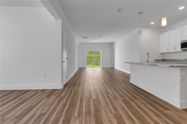 unfurnished living room with sink and dark wood-type flooring