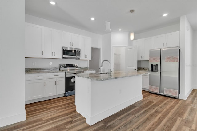 kitchen featuring hardwood / wood-style flooring, stainless steel appliances, and white cabinets