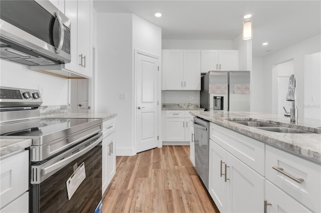 kitchen with light hardwood / wood-style floors, stainless steel appliances, sink, and white cabinets