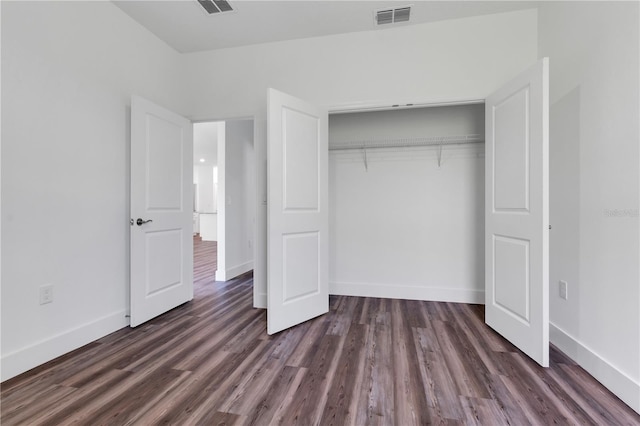 unfurnished bedroom with dark wood-type flooring and a closet