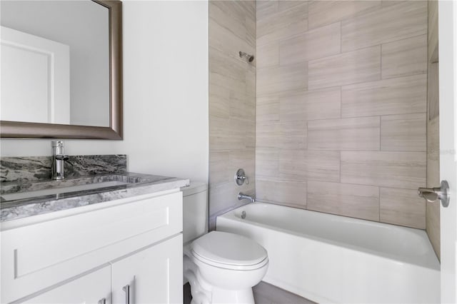 full bathroom featuring vanity, tiled shower / bath combo, and toilet