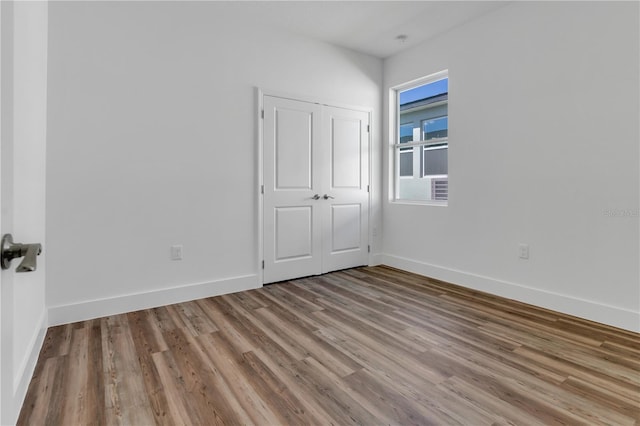 unfurnished bedroom featuring light hardwood / wood-style floors and a closet